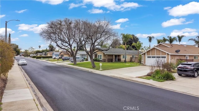 view of street featuring sidewalks, street lights, curbs, and a residential view