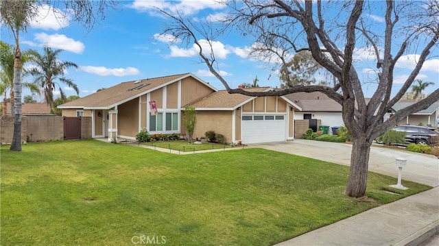 view of front facade with stucco siding, fence, concrete driveway, an attached garage, and a front yard