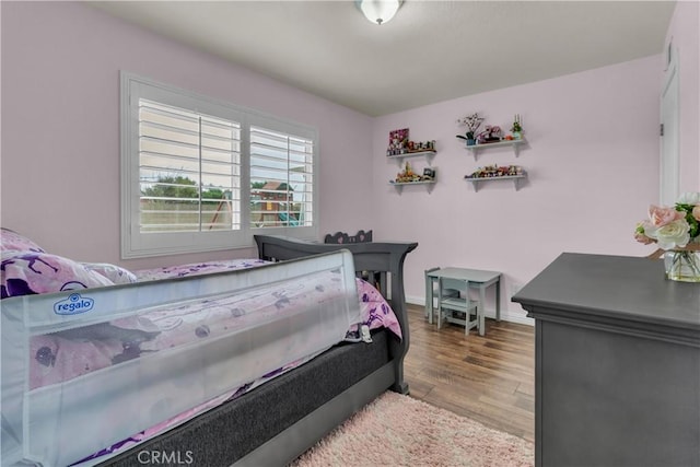 bedroom featuring wood finished floors and baseboards