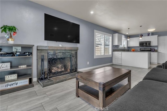 living room featuring recessed lighting, a fireplace, and baseboards