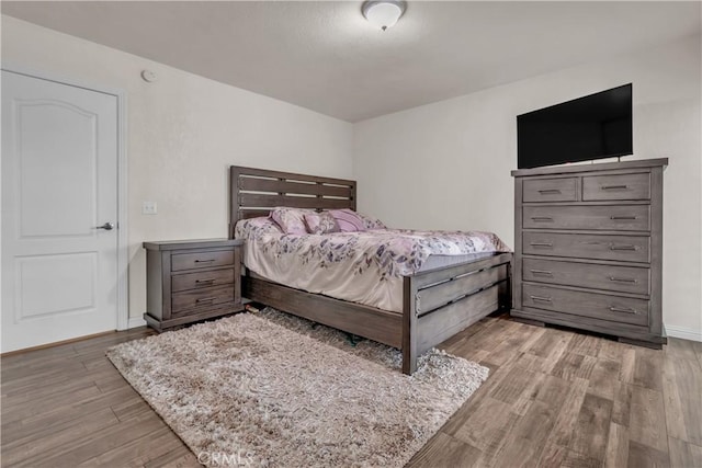 bedroom with baseboards and wood finished floors