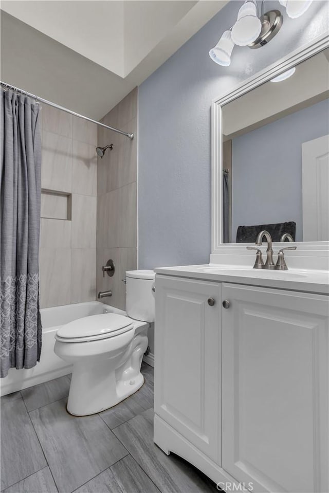 bathroom featuring shower / bathtub combination with curtain, toilet, and vanity