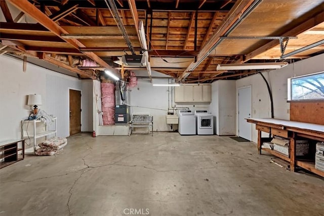 garage featuring independent washer and dryer and a sink