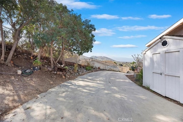 view of street with a mountain view and concrete driveway