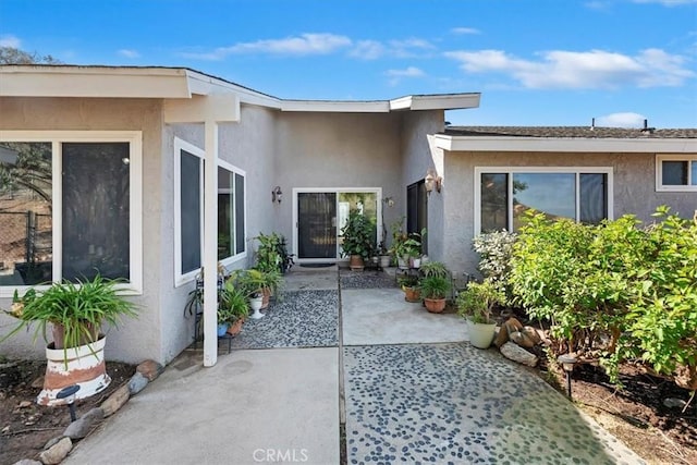 doorway to property with a patio and stucco siding