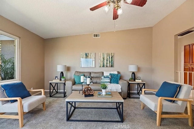 living area featuring a ceiling fan, a textured ceiling, visible vents, and carpet flooring