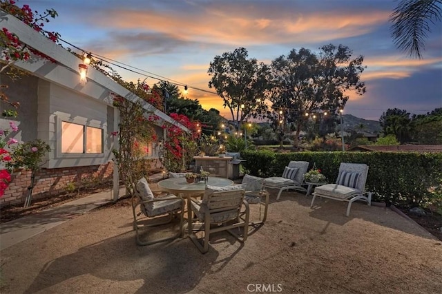 patio terrace at dusk featuring outdoor dining space