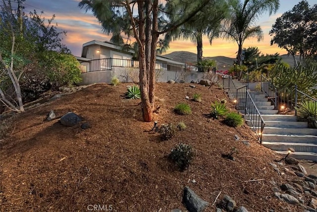 view of yard featuring fence and stairs