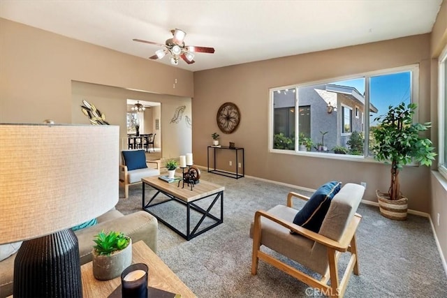 carpeted living area featuring ceiling fan and baseboards