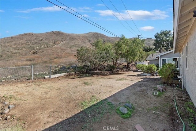 view of yard featuring fence and a mountain view