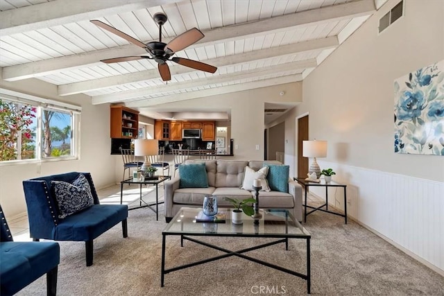 living room featuring vaulted ceiling with beams, visible vents, wainscoting, light carpet, and wooden ceiling