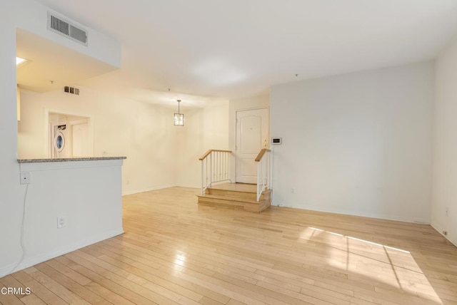 spare room with baseboards, visible vents, and light wood-type flooring