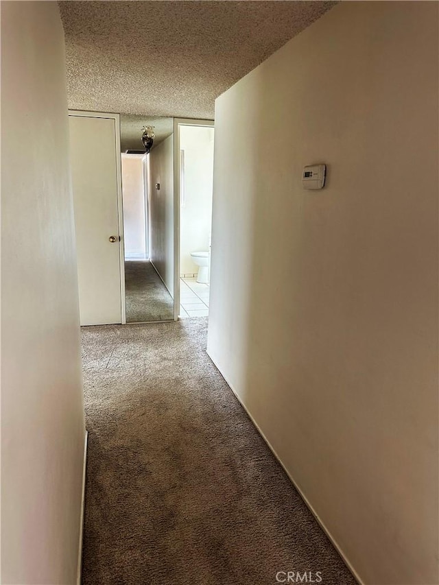 corridor featuring carpet and a textured ceiling