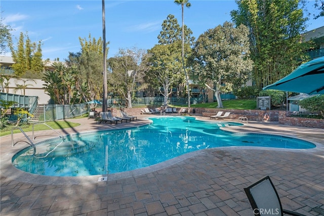 community pool featuring a patio area and fence