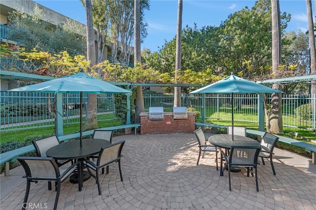 view of patio / terrace with outdoor dining space, exterior kitchen, grilling area, and fence