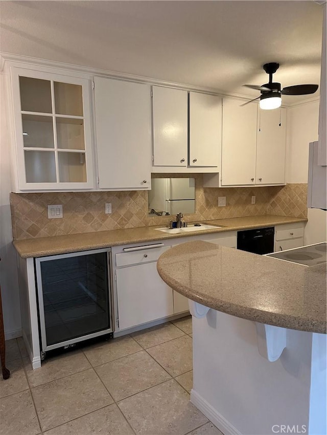 kitchen featuring wine cooler, black dishwasher, white cabinetry, a kitchen breakfast bar, and tasteful backsplash