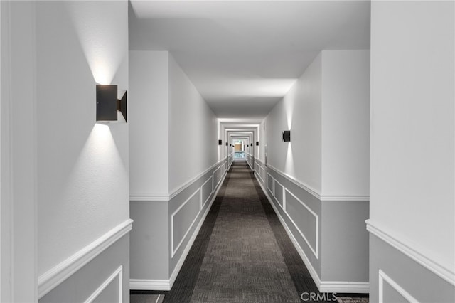 corridor with wainscoting and a decorative wall