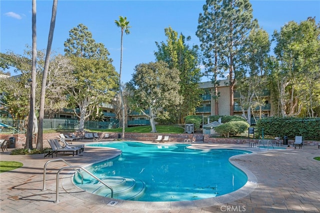 community pool featuring a patio and fence