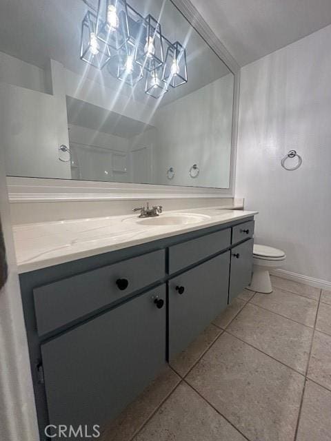 bathroom with toilet, vanity, and tile patterned flooring