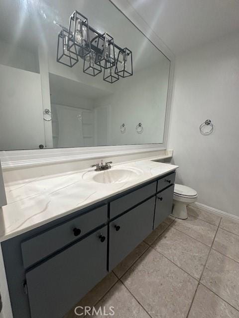 bathroom featuring tile patterned floors, toilet, vanity, and baseboards