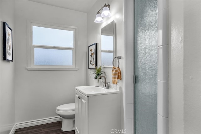 full bathroom featuring baseboards, a shower, toilet, wood finished floors, and vanity