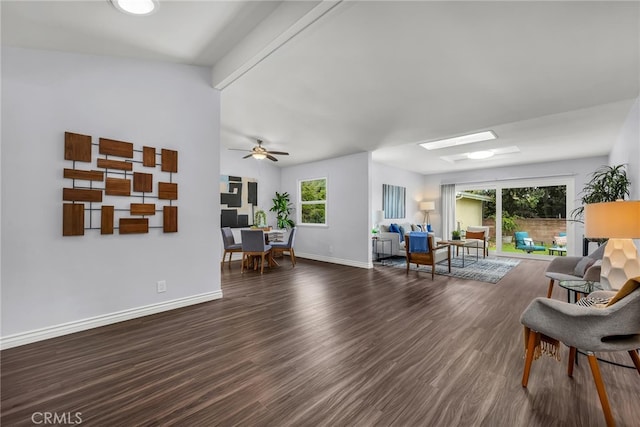 living room with a healthy amount of sunlight, baseboards, and wood finished floors