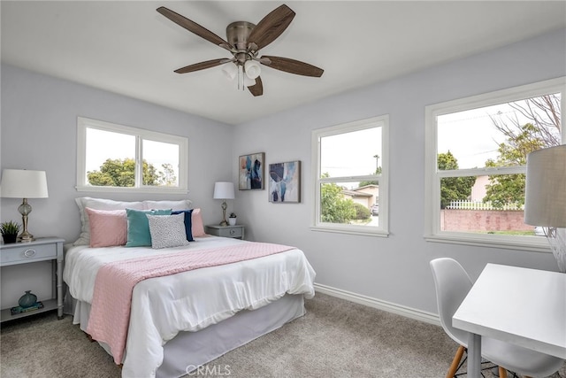 bedroom featuring carpet floors, multiple windows, ceiling fan, and baseboards