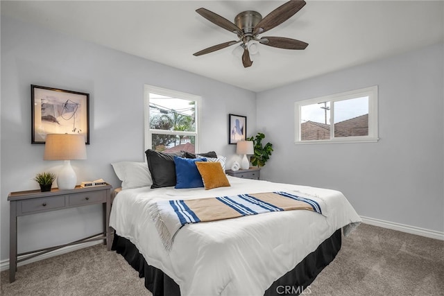 bedroom with carpet floors, multiple windows, baseboards, and a ceiling fan