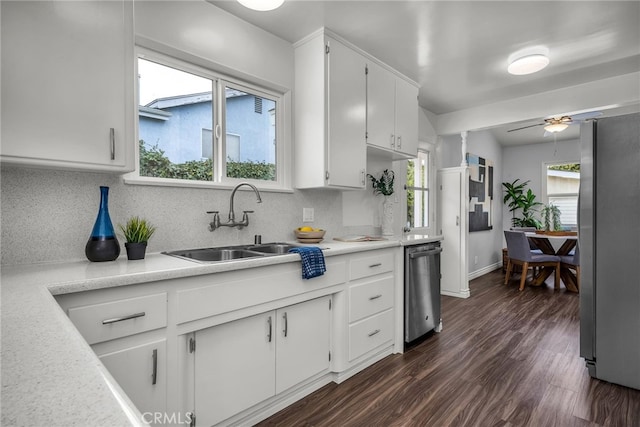 kitchen featuring appliances with stainless steel finishes, white cabinets, light countertops, and dark wood finished floors