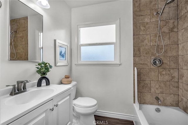 bathroom with toilet, tub / shower combination, vanity, wood finished floors, and baseboards