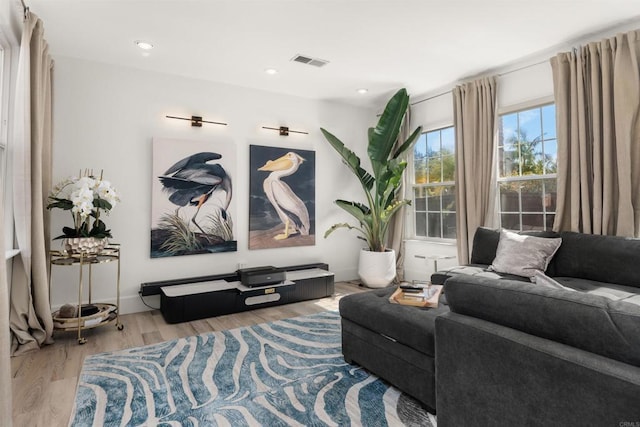 living room with visible vents, recessed lighting, and wood finished floors