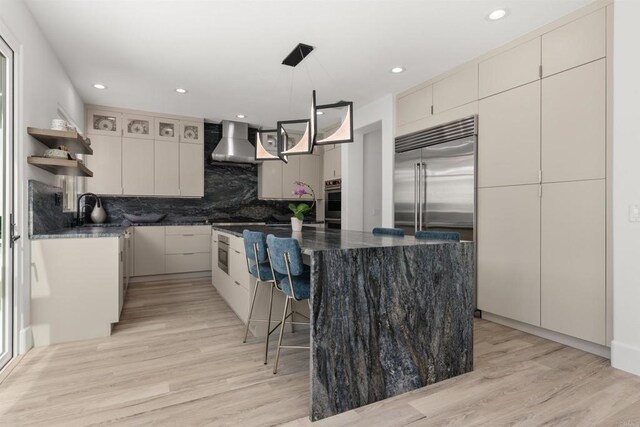 kitchen featuring open shelves, a sink, decorative backsplash, stainless steel appliances, and wall chimney exhaust hood