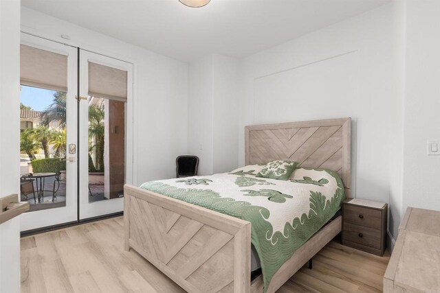 bedroom with french doors, access to exterior, and light wood-style flooring