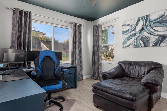 home office with baseboards and light wood finished floors