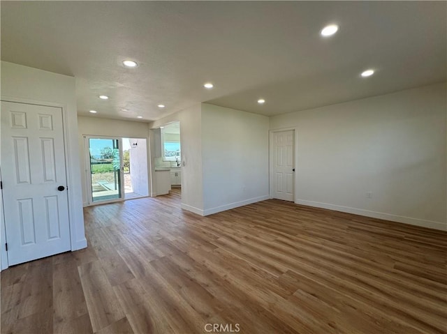 unfurnished room with recessed lighting, baseboards, and wood finished floors