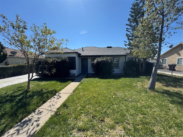 view of front of home featuring stucco siding, a front lawn, and fence