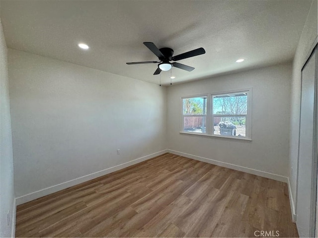 empty room featuring recessed lighting, baseboards, and wood finished floors