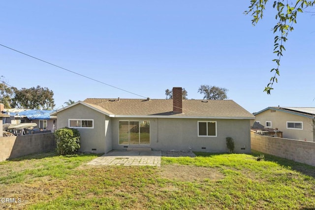 back of house featuring crawl space, a chimney, fence, and stucco siding