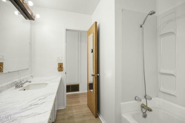 full bath with shower / bathtub combination, wood finished floors, vanity, visible vents, and baseboards