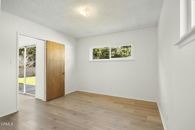 empty room with baseboards, wood finished floors, and a healthy amount of sunlight