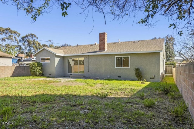 rear view of house with crawl space, a lawn, and stucco siding