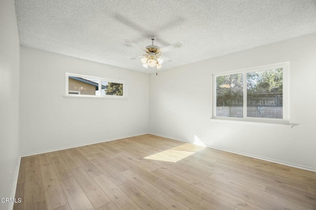 unfurnished room featuring ceiling fan, a textured ceiling, wood finished floors, and a healthy amount of sunlight