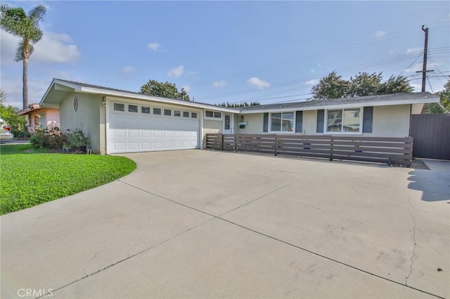 ranch-style house with a garage, fence, concrete driveway, stucco siding, and a front yard