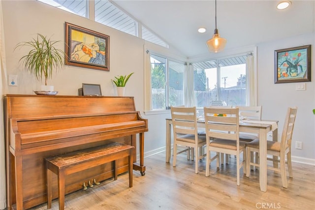 dining room with recessed lighting, vaulted ceiling, baseboards, and wood finished floors