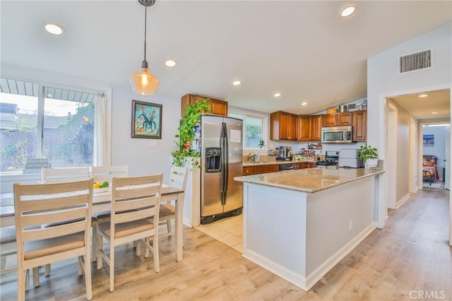 kitchen featuring visible vents, brown cabinetry, appliances with stainless steel finishes, a peninsula, and recessed lighting