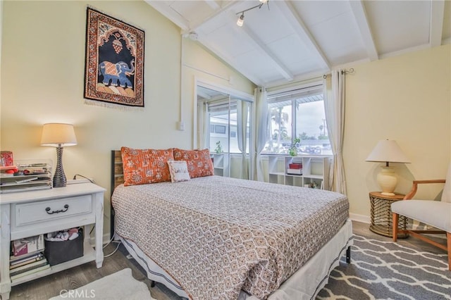 bedroom with lofted ceiling with beams, baseboards, and wood finished floors