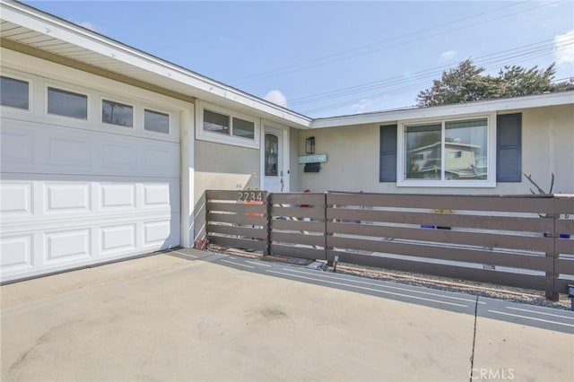 view of front of house featuring driveway, a fenced front yard, and an attached garage