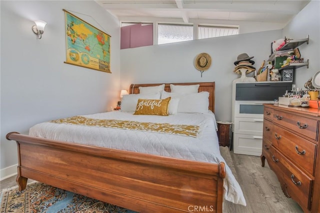 bedroom featuring lofted ceiling with beams and light wood-type flooring