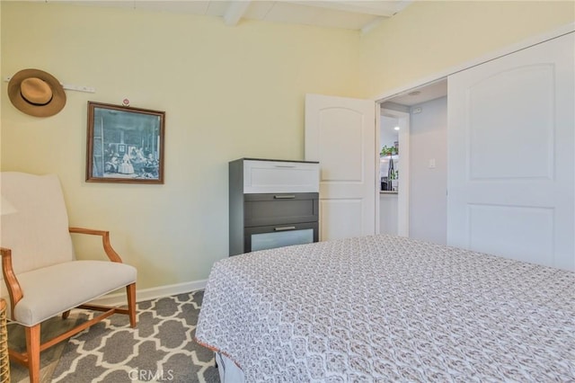 bedroom with beam ceiling and baseboards