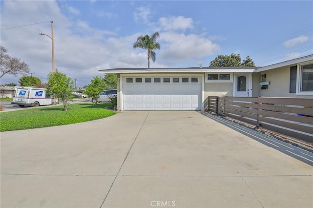 garage with fence and concrete driveway